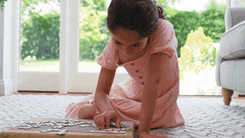 Dziewczynka układa puzzle – jeden element po drugim