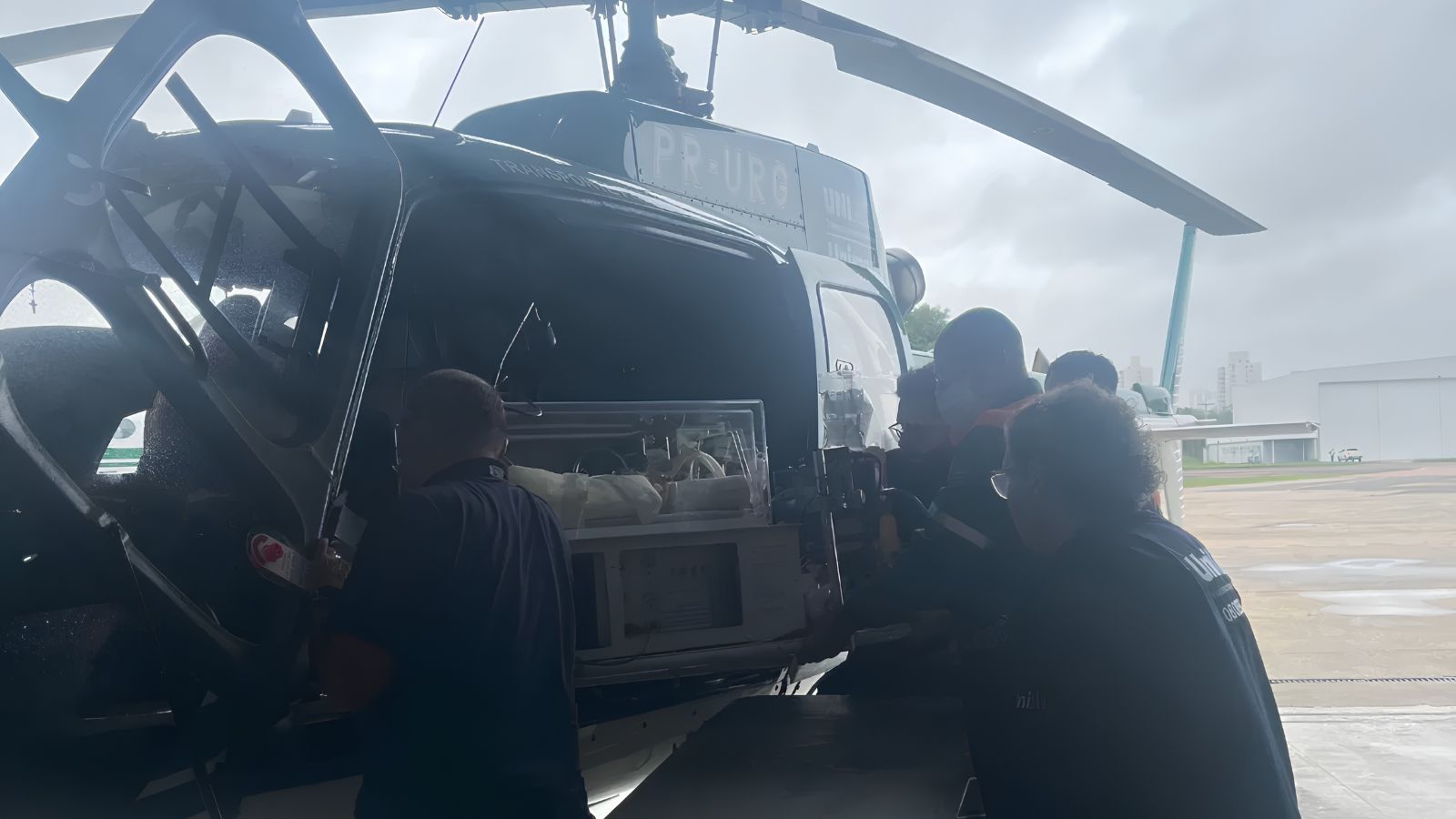 Equipe da UniAir embarcando incubadora em helicóptero para transporte aeromédico neonatal