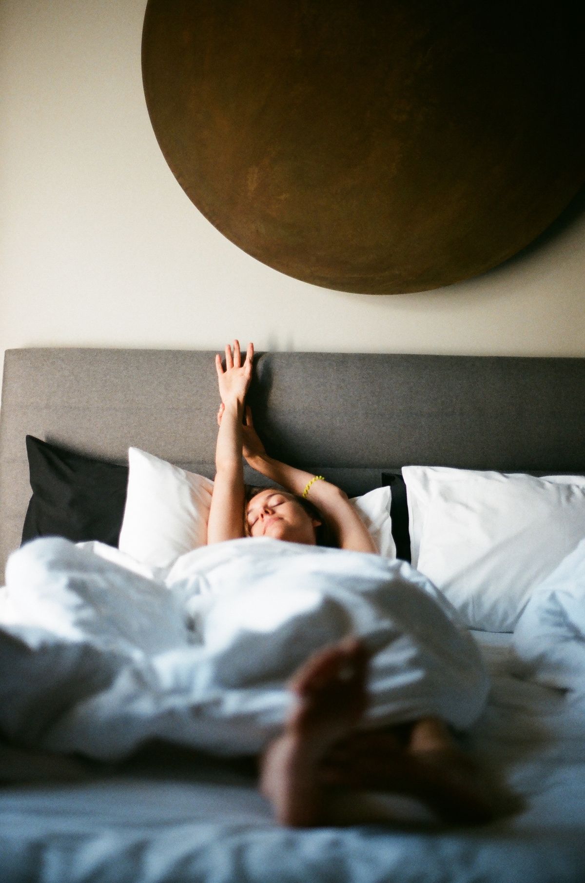 Mulher espreguiçando na cama, descansada e revigorada pela manhã depois de dormir profundamente