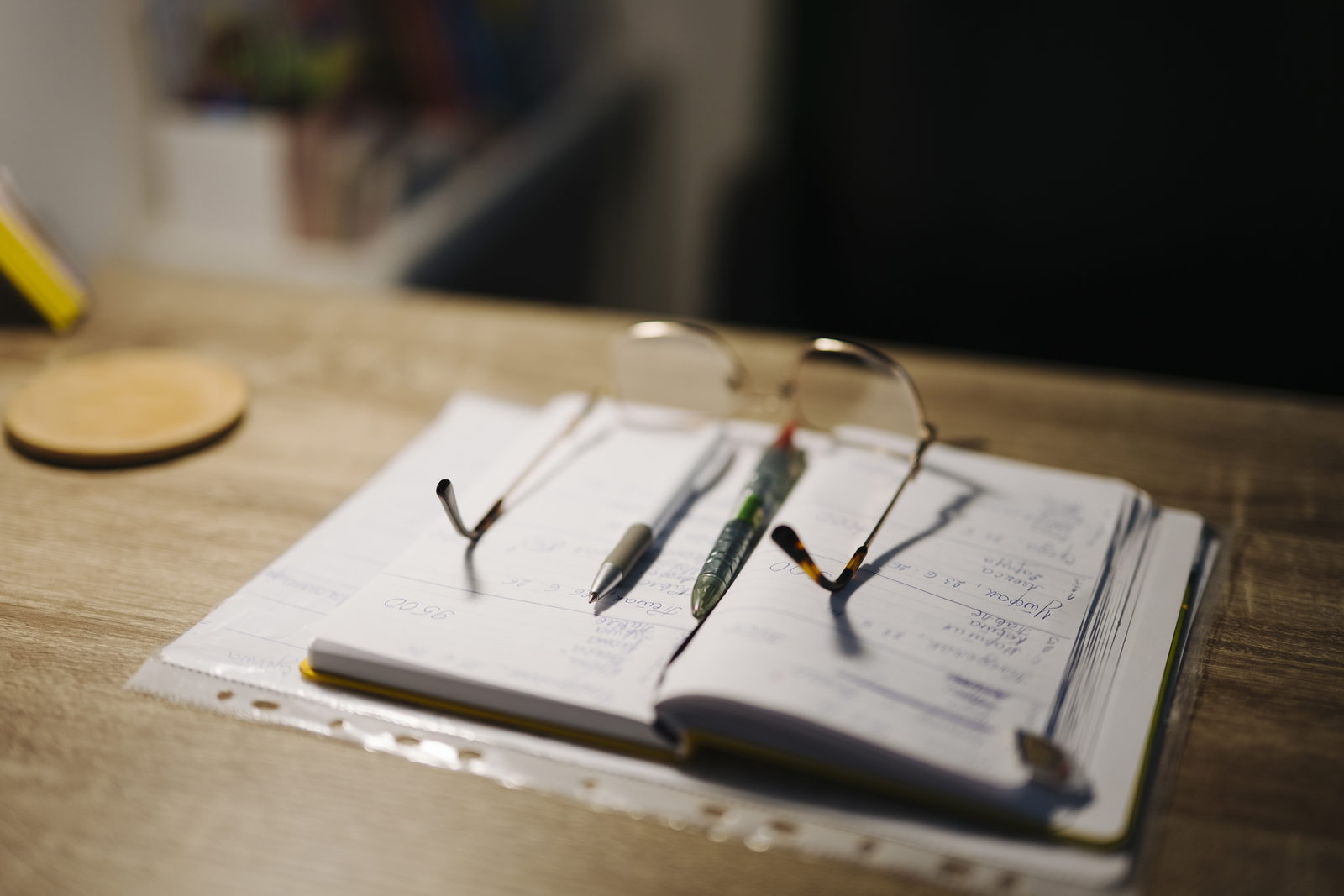 Cuaderno, bolígrafos y gafas para organizar recuerdos y notas