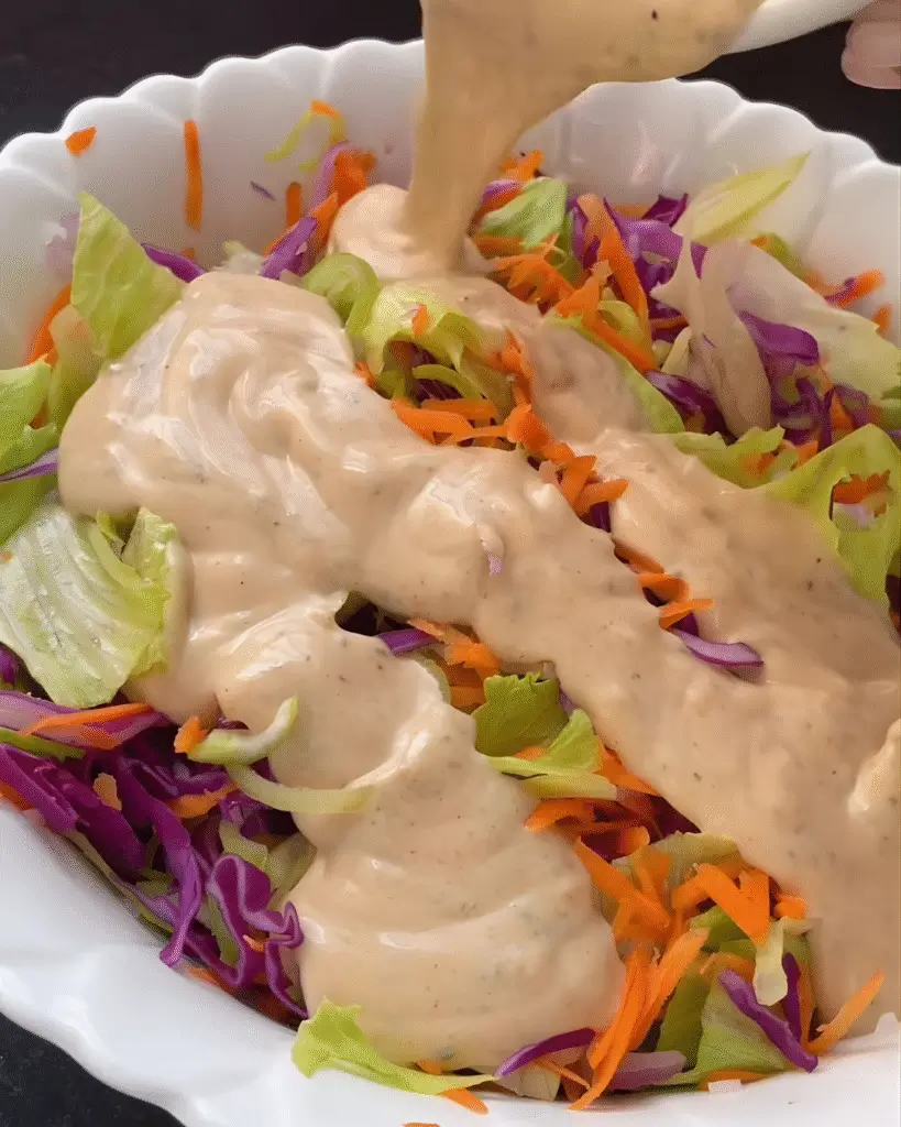 Aderezo cremoso servido sobre una ensalada colorida