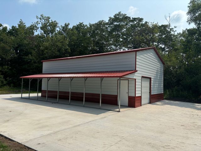 28x40x14 metal garage with red trim and an open lean-to