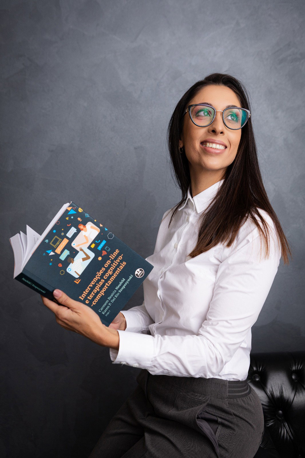 Elaine Capistrano, psicóloga, com livro de referência