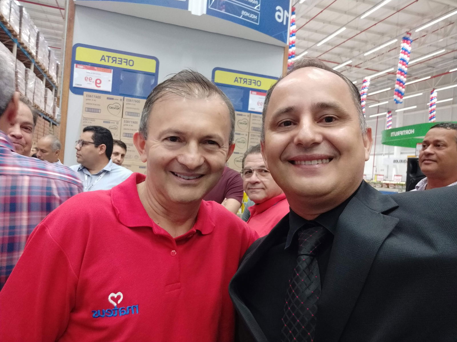 Fotografia num encontro empresarial, ao lado de um participante de vermelho