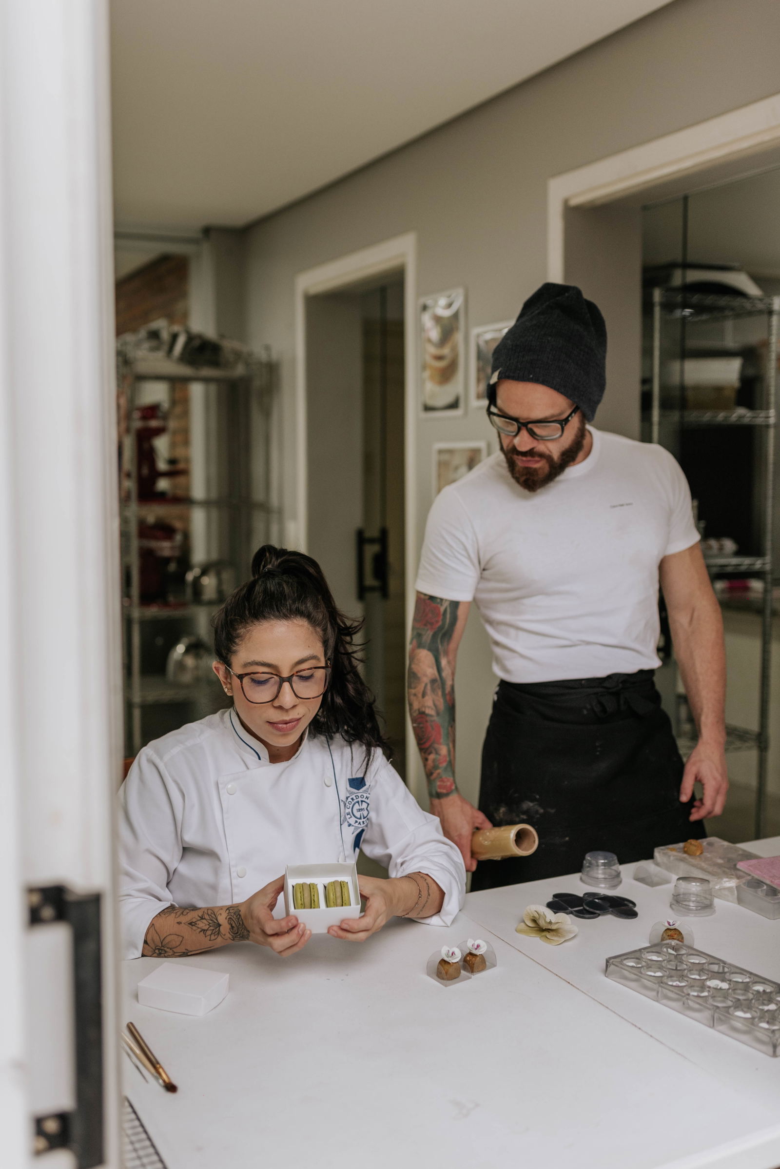 Chef Bárbara Melendez segurando macarons no ateliê